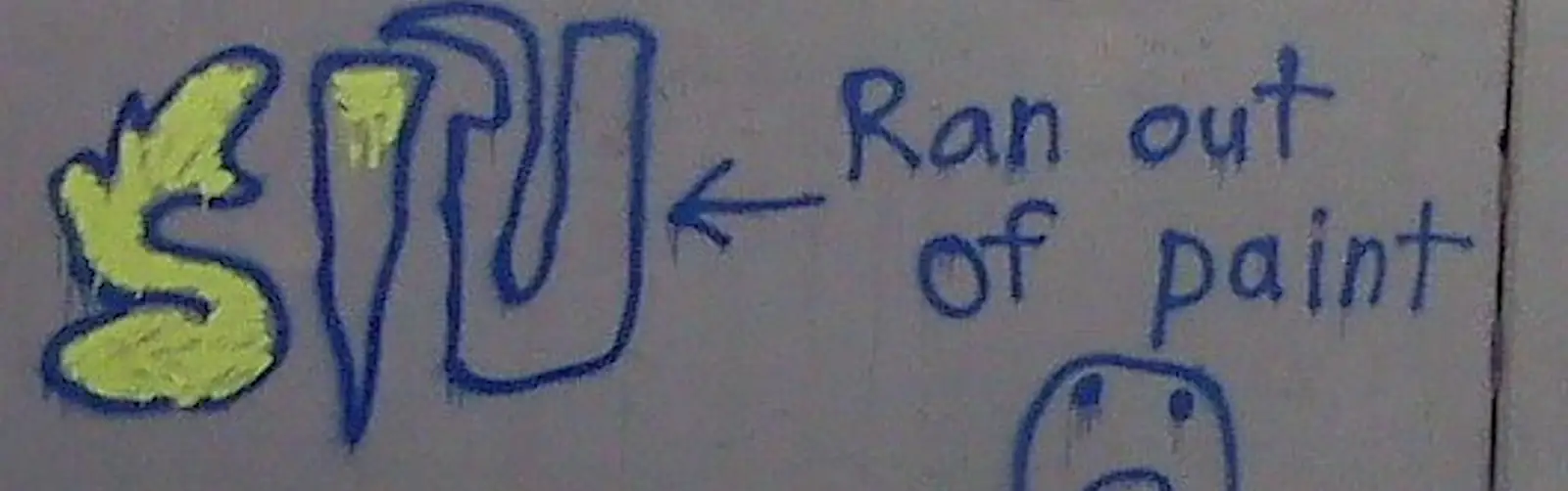 Graffiti on a wall with the words 'Ran out of paint' and a sad face
