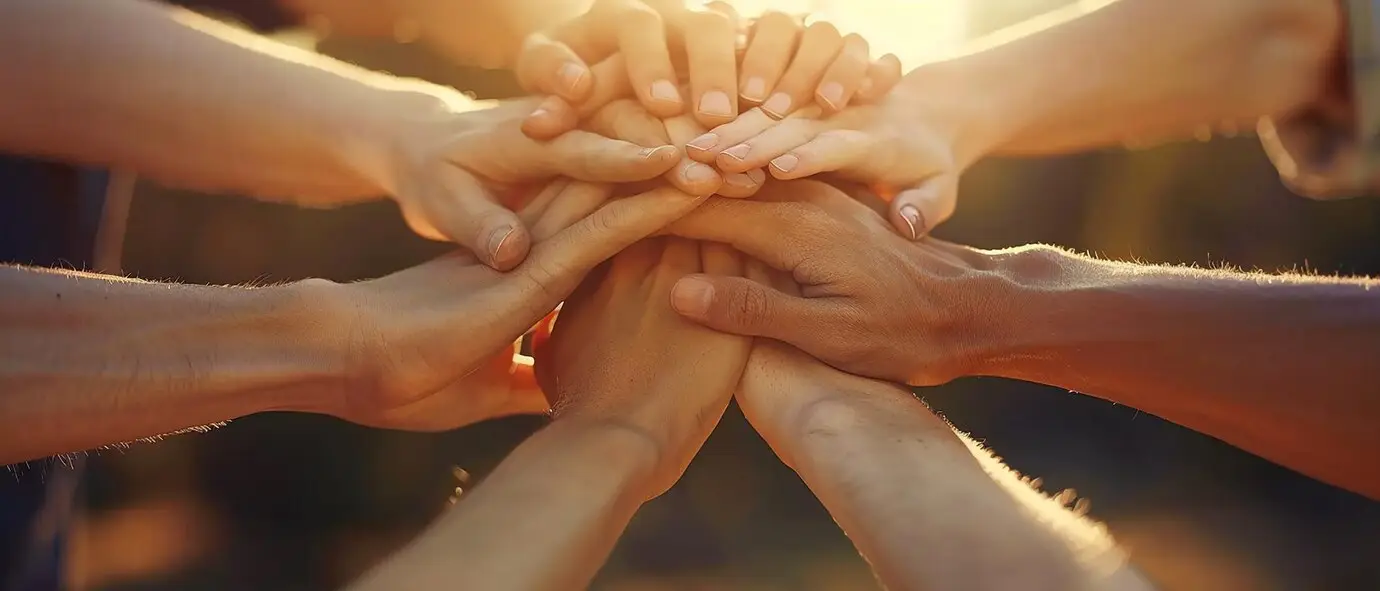 A group of hands stacked together in a show of teamwork