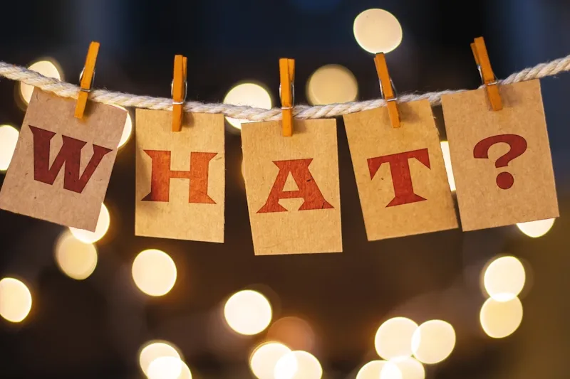 Cards pegged to a string spelling out 'What?'